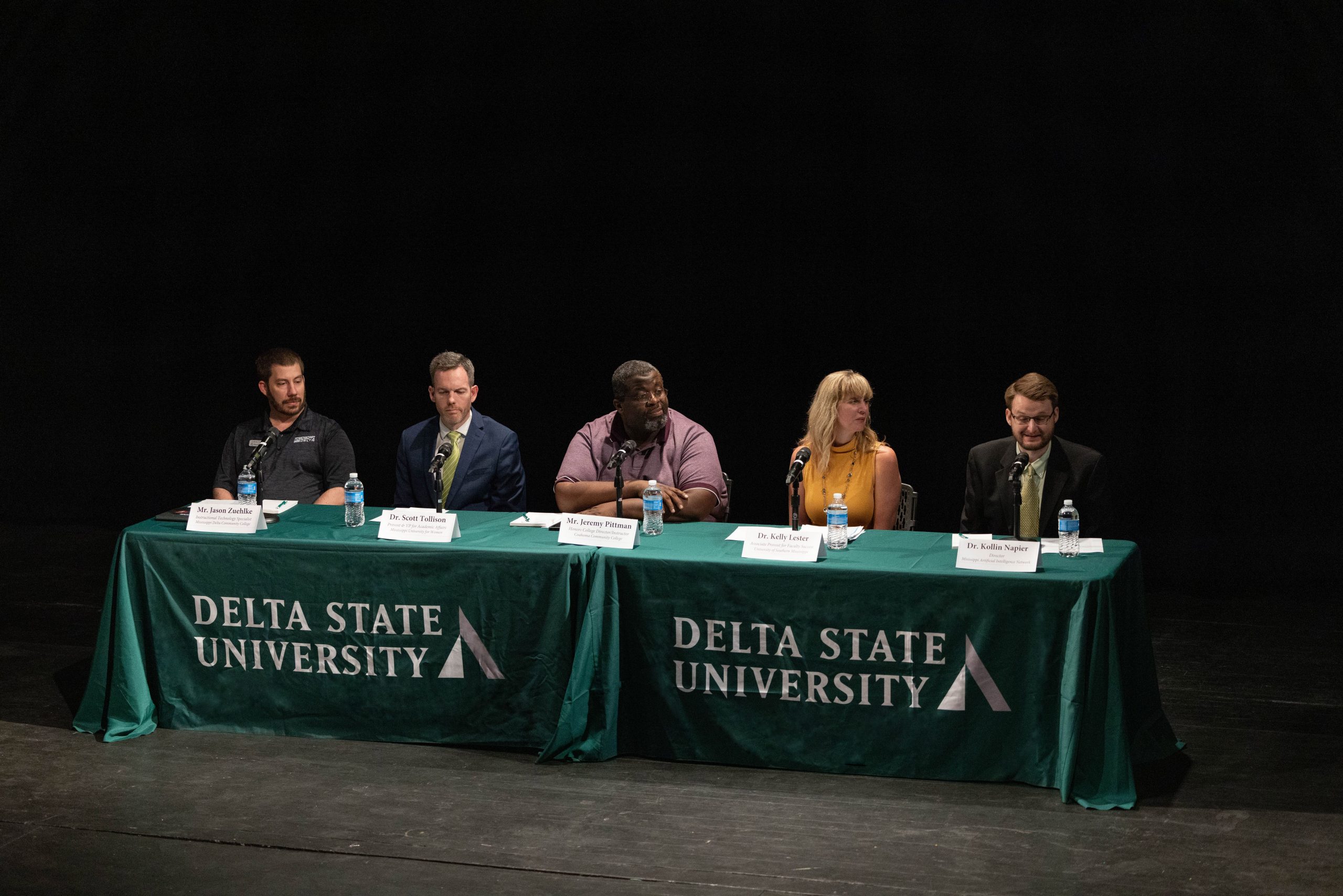 Five panelists seated at microphones during the Delta State University AI panel