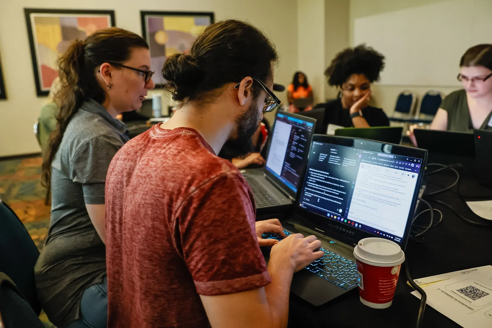 Participants working with AI tools on laptops during a MAIN workshop