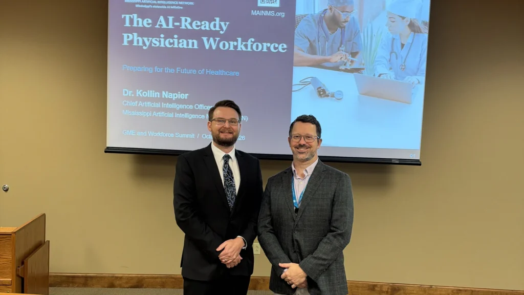 Dr. Kollin Napier, left, and Dr. Richard Calderone stand in front of The AI-Ready Physician Workforce presentation at the GME and Workforce Summit.